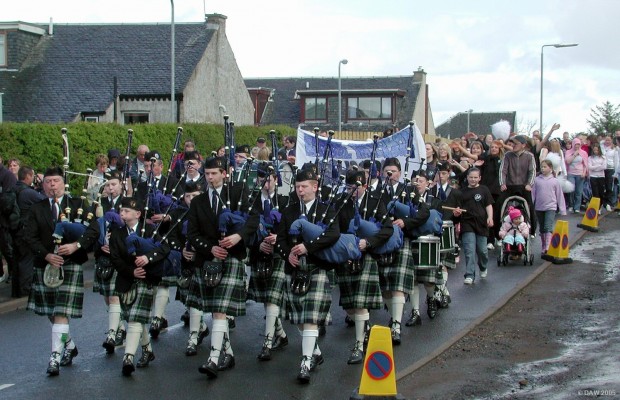 2005, parade through the village
The Boys Brigade Pipe band leads the parade through the village despite rain and hail stones.
