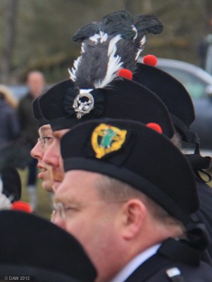 2013, Feather in your Cap
The gold cap badge of The Neilston Pipe band contrasting with the silver badge and feather of The Rothbury Pipe Band.   Neilston Pipe band has had a link with the Rothbury band from Northumberland for 35 years but its only in the last 2 years members of Rothbury band have taken part in the Neilston Show.
