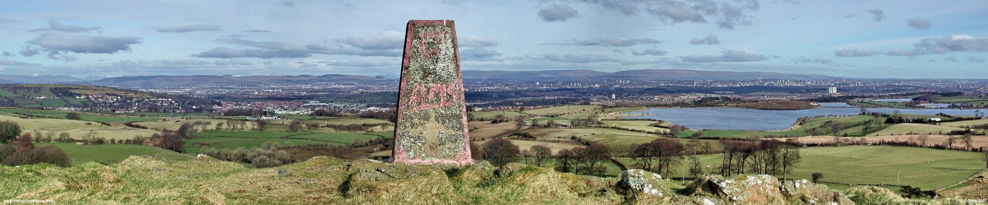Panoramic view from the top of 'The Craigie'
Looking North East from the top of Duncarnock hill.  On the left you can see Barrhead creeping up the Fereneze hills.  In the distance covering the entire width of the photo is Greater Glasgow with Paisley on the left hand side.  The concrete block is one of the thousands of 'trig' points placed around the UK between 1935 and 1962 by the Ordnance Survey. [url=http://www.streetmap.co.uk/streetmap.dll?G2M?X=250155&Y=655970&A=Y&Z=3/]Map location[/url]
