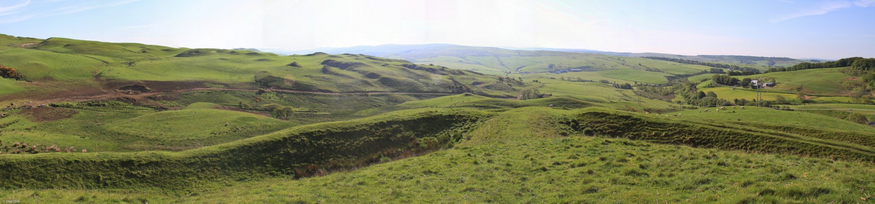 Dinvin Motte, near Girvan
A view from the top of the Motte over the entrance ramp.  The inner ring can be seen on either side and part of the lower ring is visible on the right.  Its very difficult to convey the scale of these earthworks from photos other than from [url=http://canmore.org.uk/site/297680/dinvin/] Aerial photos. [/url]
