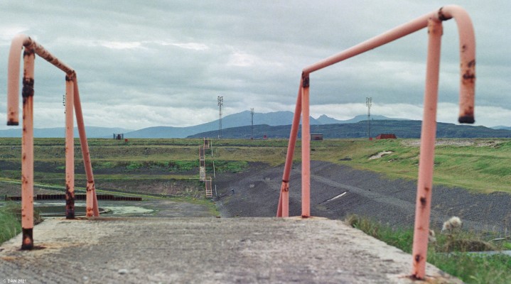 Hunterston Construction Yard, 1988
The embankment on the right was removed to allow completed fabrications to leave the construction basin.  This photo was taken in 1988 after the completion of the Maureen Alpha gravity base.  The final job in the yard was the floating munitions dock for Trident at Faslane.  The islands of Arran and the Wee Cumbrae are in the background.
