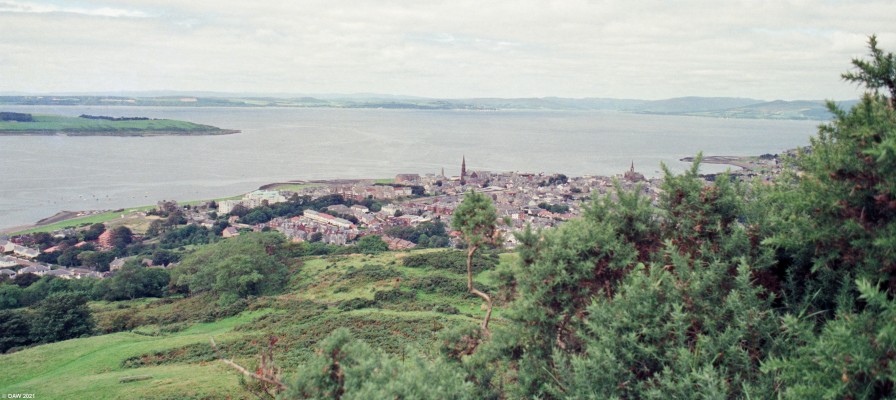 Largs from Douglas Park, 1988
A view over Largs towards Bute from the viewpoint at the top of Douglas Park.  Those who know Largs might notice the most obvious difference here being the large vacant piece of land on the left where The Marine & Curlinghall Hotel once stood.  Today there are flats on the site.  Other points of note are that the railway station canopy is still intact, this was so badly damaged in 1995 by a run away train that it had to be demolished. 
