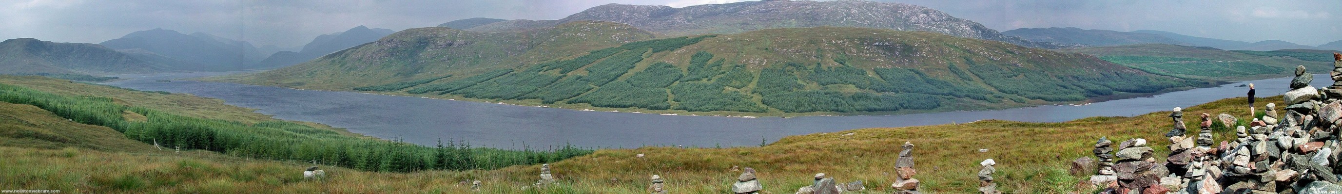 Loch Loyne panorama
A dam at the eastern end of Loch Loyne provides a head of water for the Garry-Moriston Hydo scheme.  A tunnel carries water north from here to the Cluanie dam.  This view point is littered with small cairns left by tourists.  [url=http://www.streetmap.co.uk/map.srf?X=218612&Y=804770&A=Y&Z=115&ax=218612&ay=804770/] Map location. [/url]
