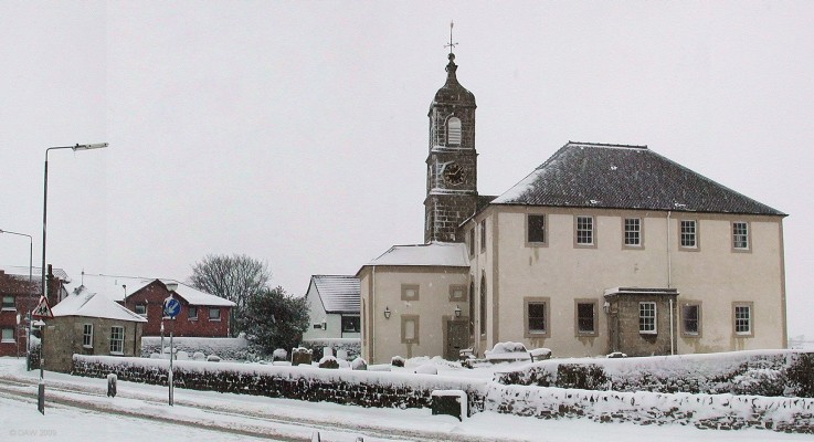 Neilston Parish Church, 2006
A view of the Church and graveyard taken during some unsually heavy snow.   The small stone building near the gate is the Session House and it really does slope like that.

