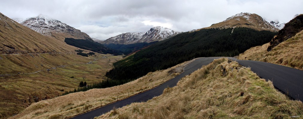 The Old Military Road, Glen Croe
A view of the old military road from the car park at the "Rest & Be thankful"  It was built as a result of the Jacobite uprisings of 1715 and 1719 and completed in 1749.  Nearly 250 years later it is back in use as a diversion route in the event of land slides blocking its 'modern' replacement.  The road disappears here to the left in  a steep corkscrew and can be seen lower down in the Glen with the modern road above. 
