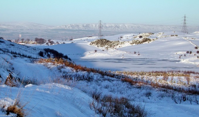 Snypes Dam, winter
A view over the almost frozen Snypes dam in winter.  In the distance Glasgow can be seen in the valley below.  I think the tower block on the left side is probably the one a way over at Anniesland Cross.  [url=http://www.multimap.com/map/browse.cgi?lat=55.7647&lon=-4.4253&scale=25000&icon=x/]Map Location[/url]
