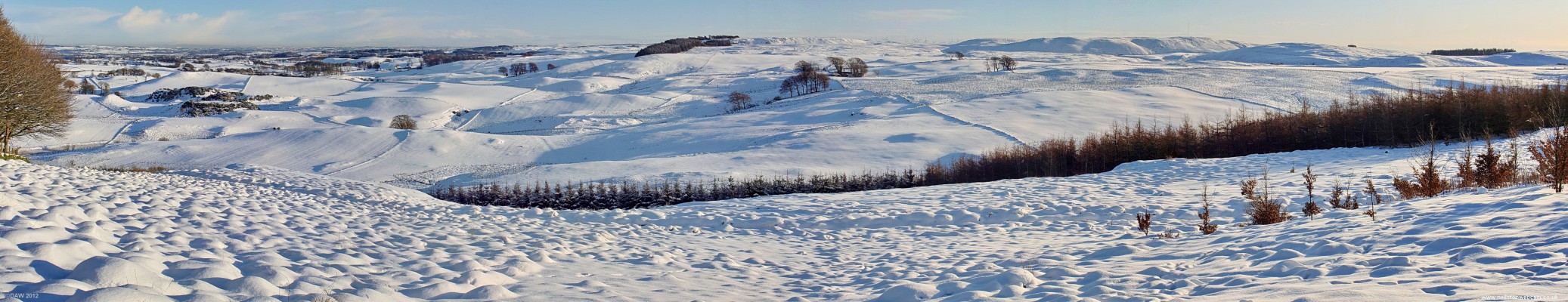 South East panoramic view from Neilston Pad, 2010
On the left in the distance is the south side of Glasgow, in the centre you can just see Whitelee Windfarm turbines above some of the hills.  On the right is a frozen Harelaw Dam.  You might also make out the anenometer mast on top of James's Hill towards the right. [url=http://www.streetmap.co.uk/map.srf?X=247510&Y=654890&A=Y&Z=120/] Map location. [/url]
