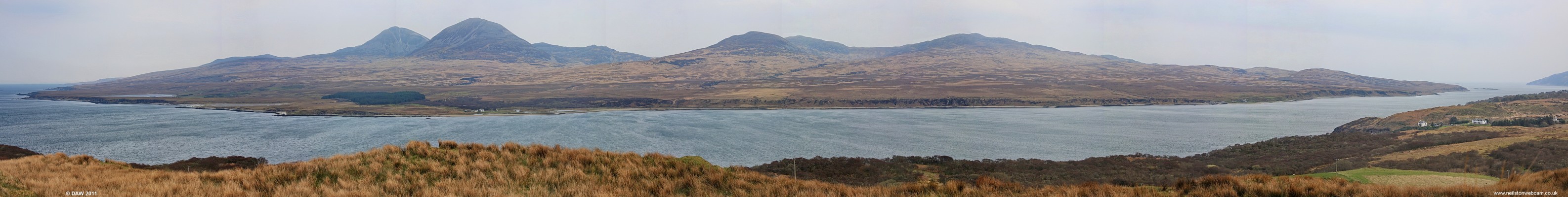 The Isle of Jura
Panoramic view of the south end of the Isle of Jura.  The Paps of Jura dominate the island, the highest rise to some 755m.   On the right you just make out the slipway for the Feolin Ferry, the main link to Islay.  [url=http://www.streetmap.co.uk/map.srf?X=142480&Y=671415&A=Y&Z=120/] Map location. [/url]
