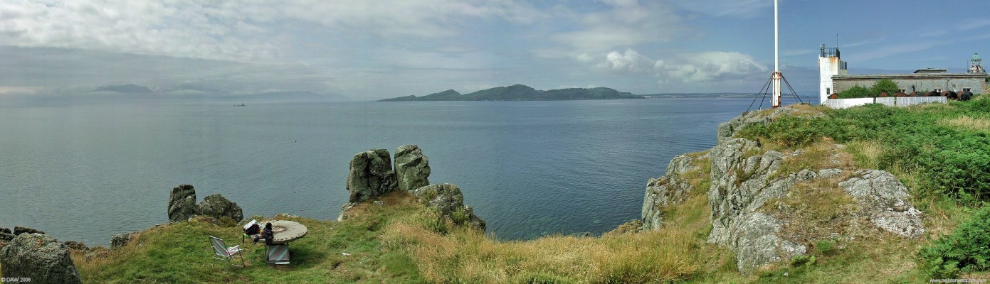 Wee Cumbrae Picnic Table
You can picture the Lighthouse Keepers family enjoying a summers day at this spot just beside the Lighthouse on the west side of the Wee Cumbrae.   On the extreme right you can see the old disused light tower, the present day automatic light is on top of the closer building, its solar panels can be seen below it.  Arran is in the mist on the left and the tail end Bute is in the centre.  A Vanguard class Ballistic Missile Submarine is on its way home to Faslane.   
