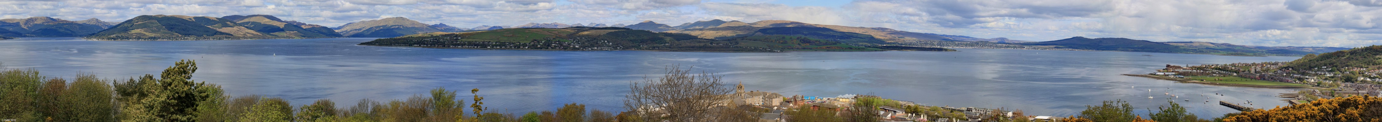 Panoramic view from Tower Hill, Gourock
Looking north across the Clyde, on the extreme left is the Holy Loch, next right is the entrance to Loch Long, the part not in sun is Rosneath Penninsula, look close and you can see Cove Pier.  Further along on the right is the town of Helensburgh. Down below is the town of Gourock and Gourock Bay.  Battery Park runs along the shore and on the extreme right is Lyle Hill. [url=http://www.streetmap.co.uk/map.srf?X=223902&Y=677360&A=Y&Z=115/] Map location. [/url]
